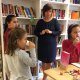 Die Kinder Leila, Asma und Marjan haben Spaß beim Lesen und Naschen.